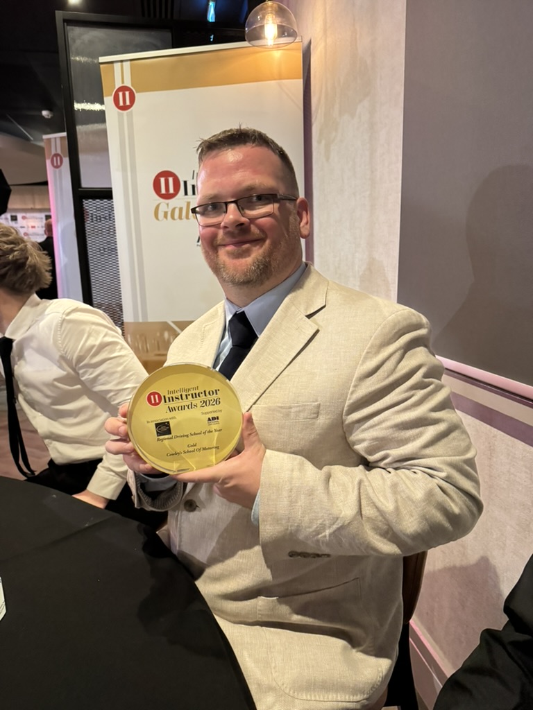 Phil Cowley holding the gold Intelligent Instructor Award 2026 for Regional Driving School of the Year